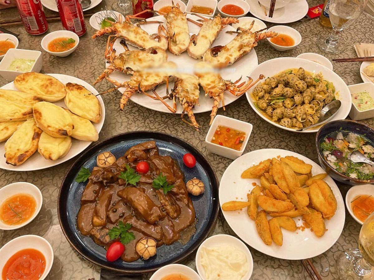 Du khách thưởng thức bữa trưa với các món hải sản và cơm phần.
